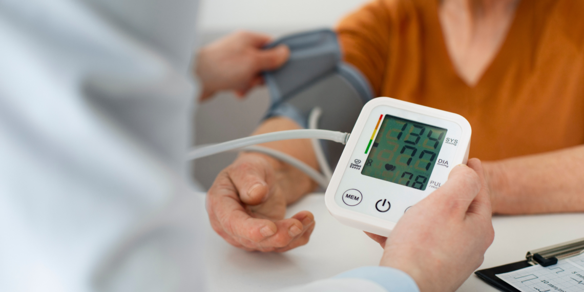 Older adult calmly checking blood pressure at home using a digital monitor