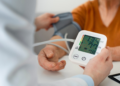 Older adult calmly checking blood pressure at home using a digital monitor