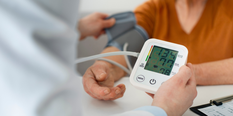 Older adult calmly checking blood pressure at home using a digital monitor