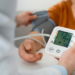 Older adult calmly checking blood pressure at home using a digital monitor